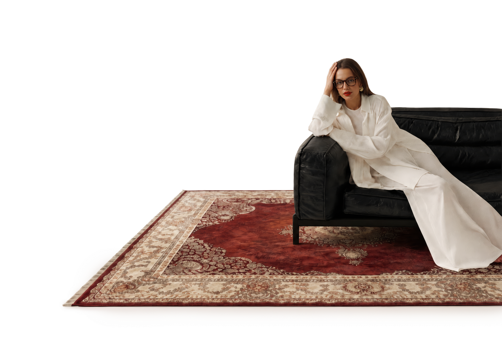 Belgin Küpeli seated beside a sofa, styled with a hand-knotted rug